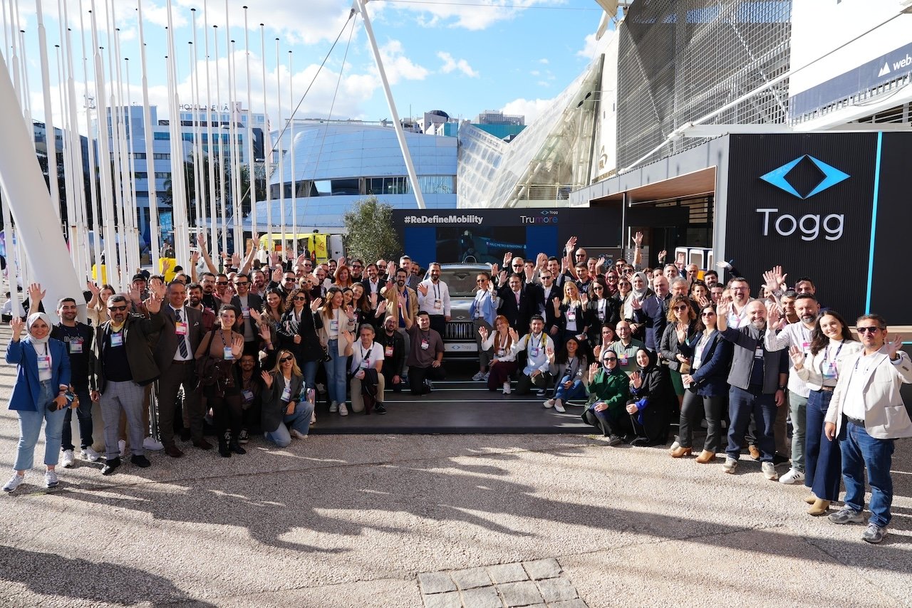 People pose for a photo in front of the Togg booth on the sidelines of the Web Summit 2024, Lisbon, Portugal. (Photo by Timur Sırt)