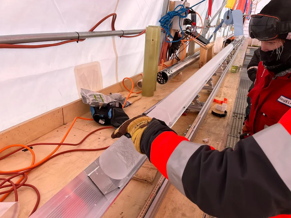 Scientists looking at a column of ice on a table