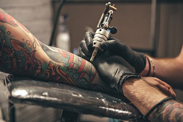 Man receiving a tattoo via a needle