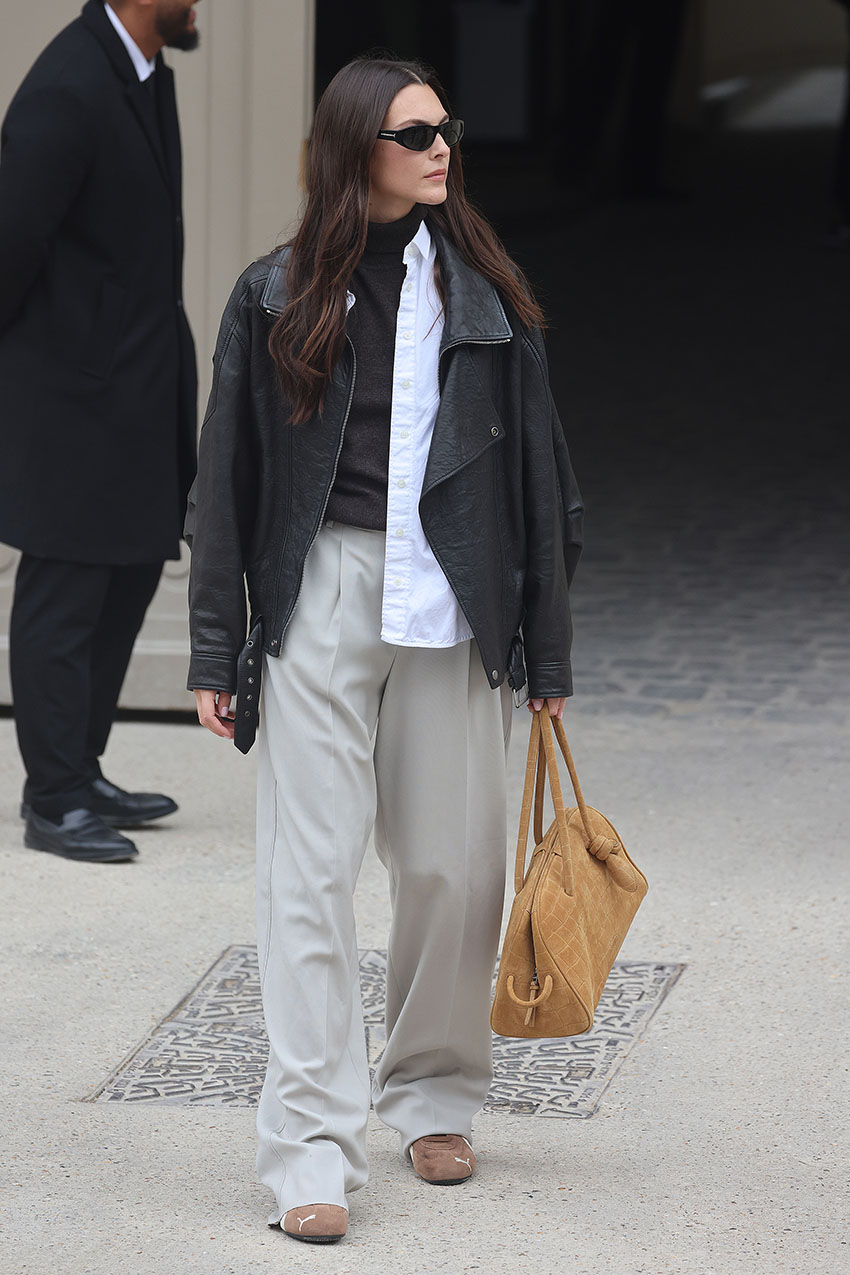 Vittoria Ceretti wearing a black leather jacket, khaki baggy pants, and tan Puma Speedcat sneakers