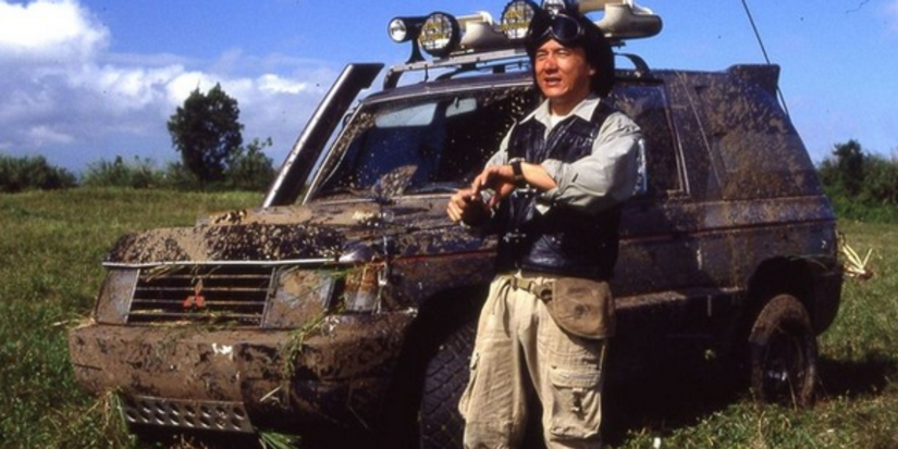 Asian Hawk (Jackie Chan) is standing by a camouflaged jeep in Armour of God II Operation Condor.