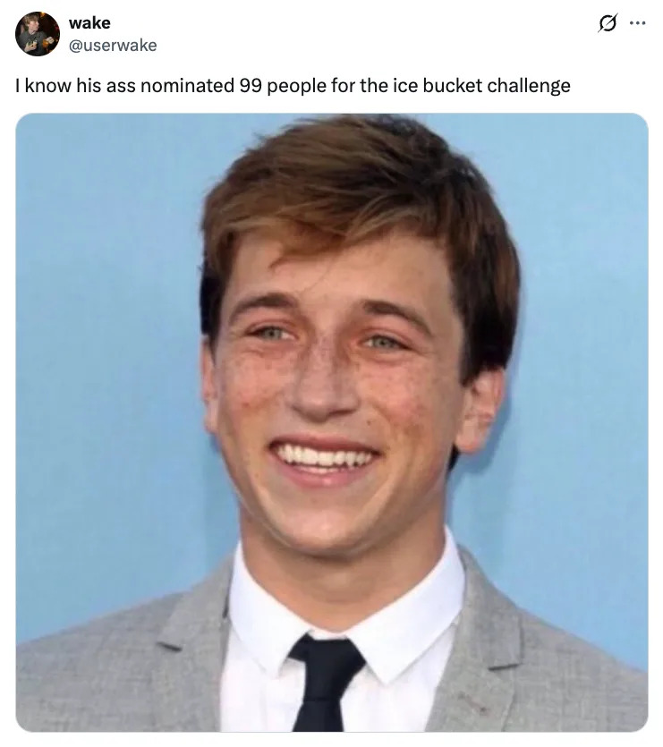 Smiling Skyler Gisondo in a gray suit and tie, standing against a plain background. Tweet text above: "I know his ass nominated 99 people for the ice bucket challenge"