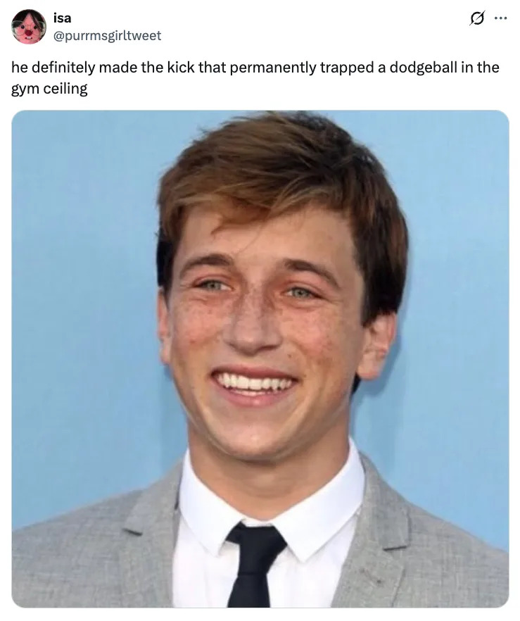 Skyler Gisondo smiling in a suit and tie, with a tweet humorously suggesting he kicked a dodgeball and got it stuck in a gym ceiling