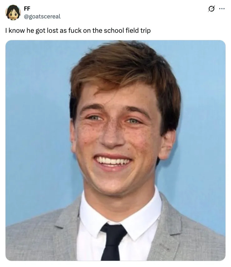 Skyler Gisondo in a suit with a tie, smiling widely. Caption above reads: "I know he got lost on the school field trip."