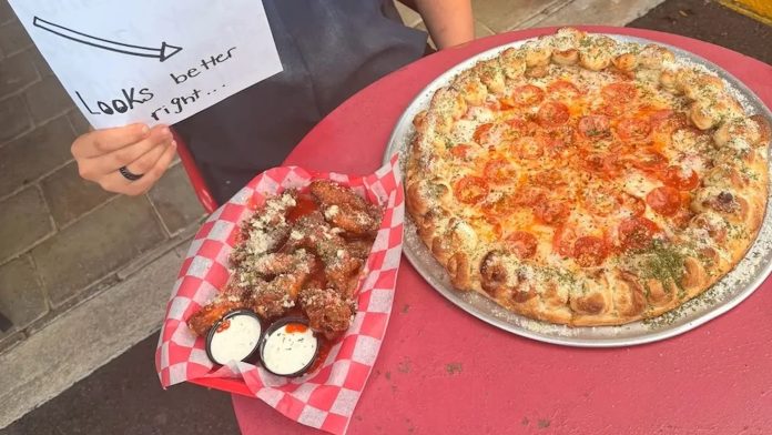 Florida pizza shop goes viral for refusing AI after hacked A pizza with pepperoni and a basket of chicken wings with dipping sauces on a red table.
