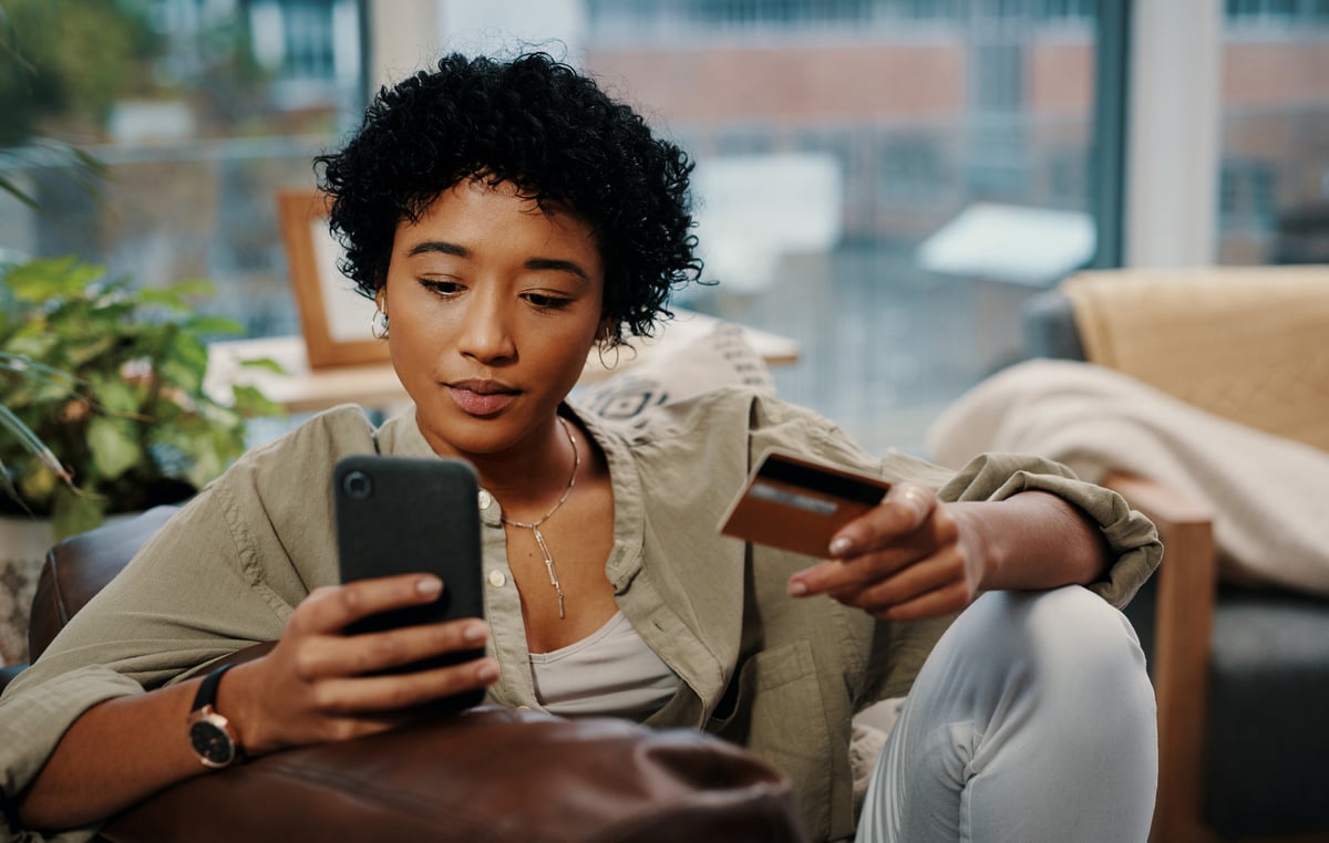 2 Fintech Stocks to Buy After Losing Over Half Their A person makes a credit card payment on a smartphone.