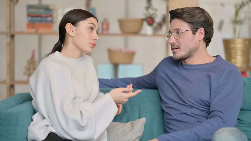 A couple talking on a sofa