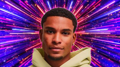 A head and shoulders shot of a man in a bright hoodie, smiling to camera, set against a sparkling purple, pink and blue background