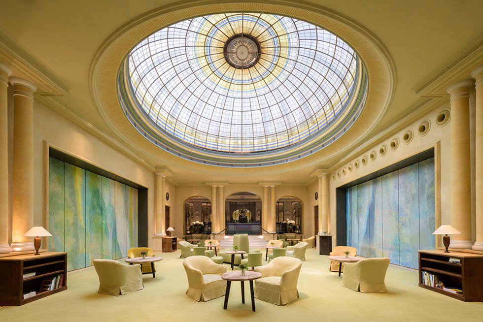 Elegant lounge area featuring soft seating, a decorative ceiling, and vibrant wall art.