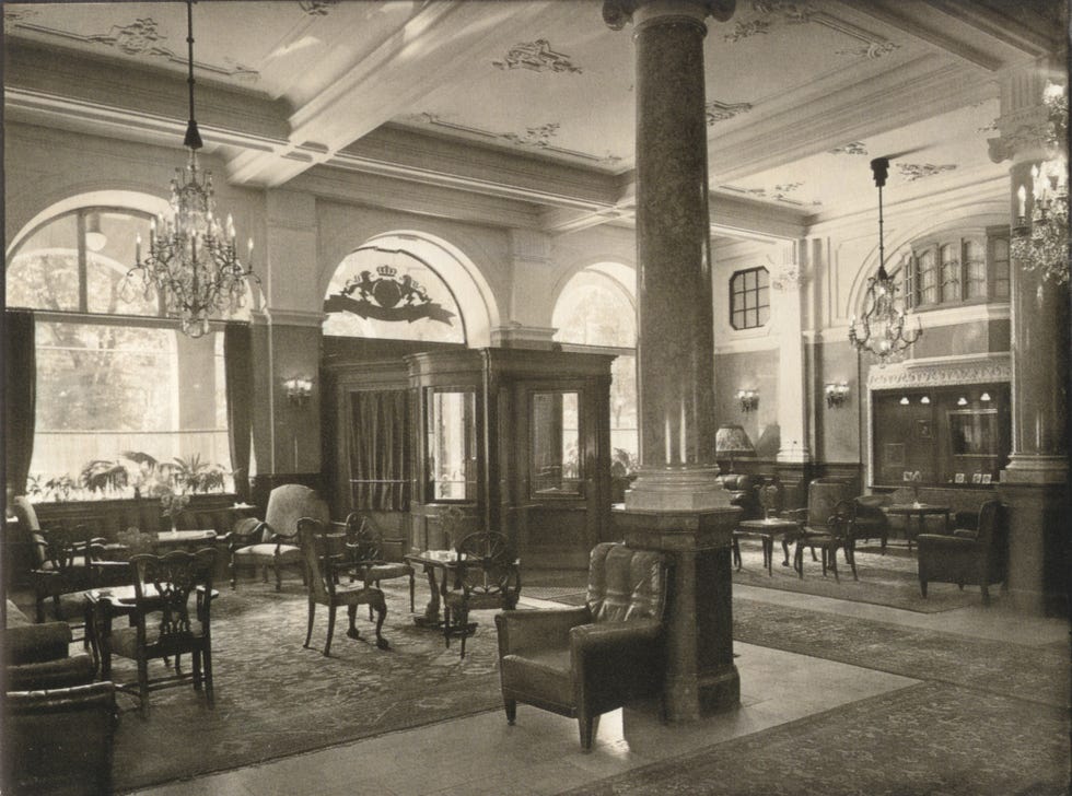 Elegant vintage lounge featuring ornate decor, chandeliers, and plush seating in a welcoming atmosphere.
