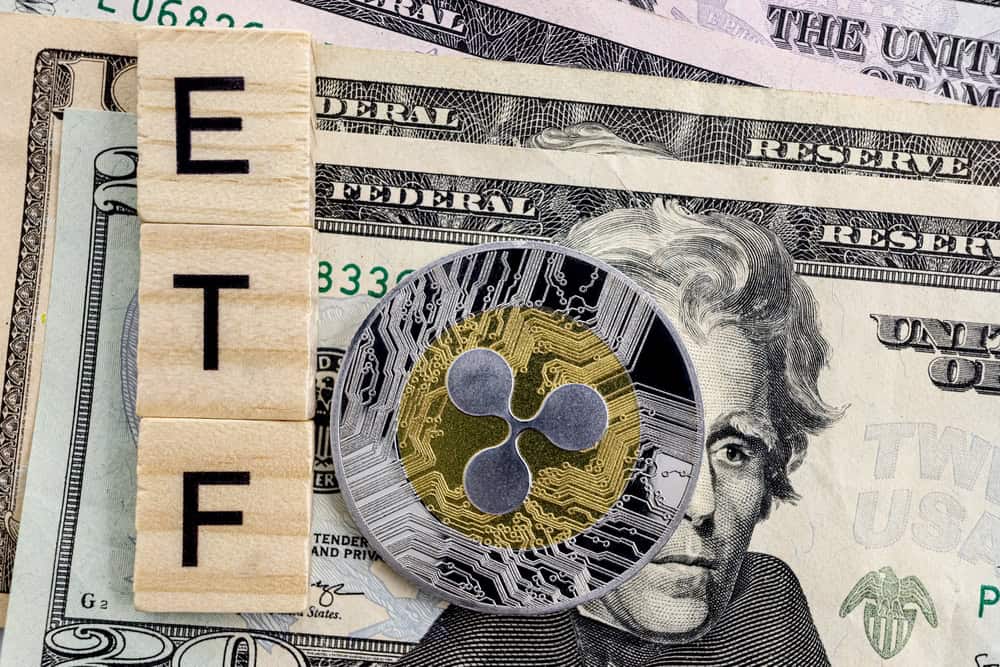 XRP’s ETFs Are $160 Million Behind Solana’s and Closing. Solana’s Funds Have Had Outflows on Six of Seven October Days. A close-up shot of three wooden Scrabble-like tiles spelling 'E', 'T', 'F' vertically on the left side. Behind them are several U.S. dollar banknotes, including twenty-dollar bills with Andrew Jackson's face partially visible. Overlapping the banknotes and Jackson's face is a round, metallic cryptocurrency coin featuring the Ripple (XRP) logo, with a gold-colored center and a silver circuit board pattern around the edge.