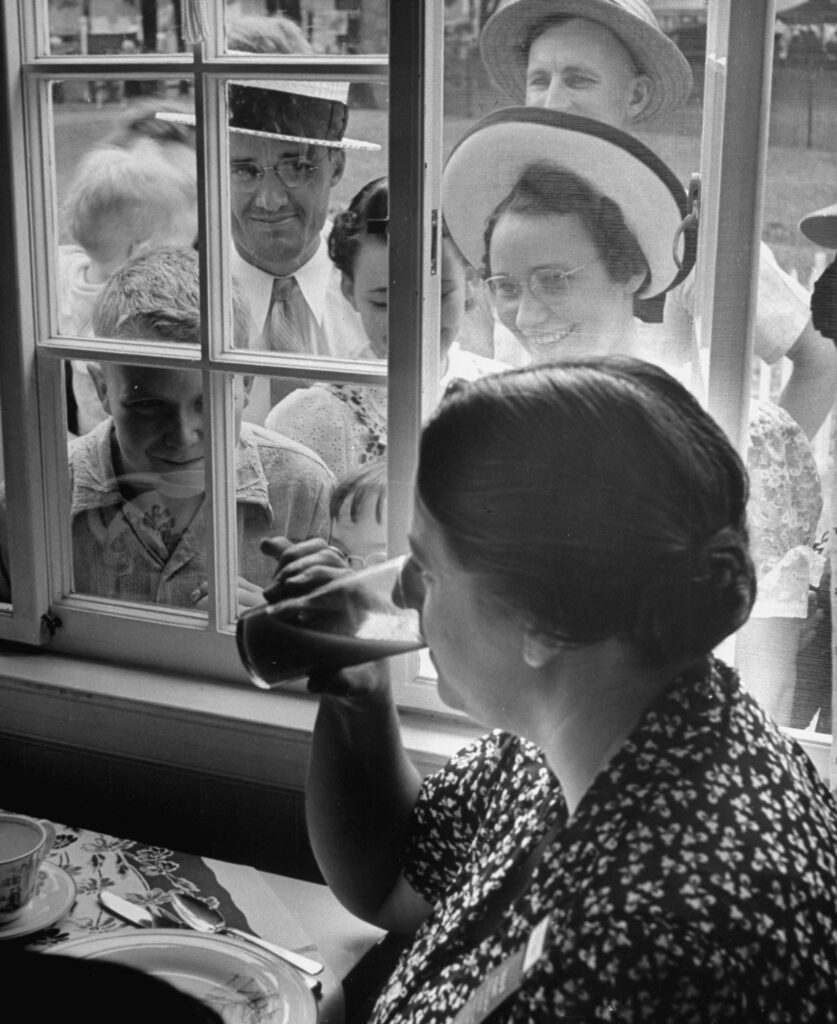Visitors to the Ohio state fair looked in "Ohio's Most Typical Farm Family," 1941; here Mrs. Frank Engels sipped tomato juice.