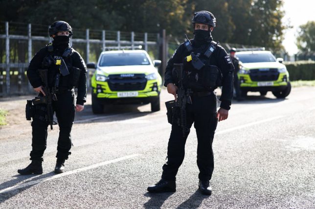 Armed police officers stand guard on a road outside the perimeter of the RAF Fairford airbase, after police declared a major incident at the base after several men were arrested on suspicion of offences under the Explosives Act, in Fairford, Gloucestershire, Britain, September 28, 2026. REUTERS/Toby Shepheard