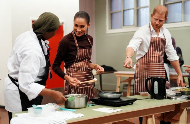 Britain's Prince Harry, Duke of Sussex and his wife Meghan, Duchess of Sussex, cook during a visit to the Himmah Hub, a food poverty community action group in Nottingham, central England on October 15, 2026. Himmah is a Nottingham charity tackling poverty, food insecurity, racism and social exclusion through community meals, food parcels and wider practical support. (Photo by Annabel Lee-Ellis / POOL / AFP via Getty Images)