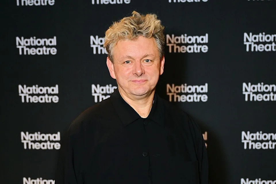 Person in dark shirt at National Theatre event backdrop