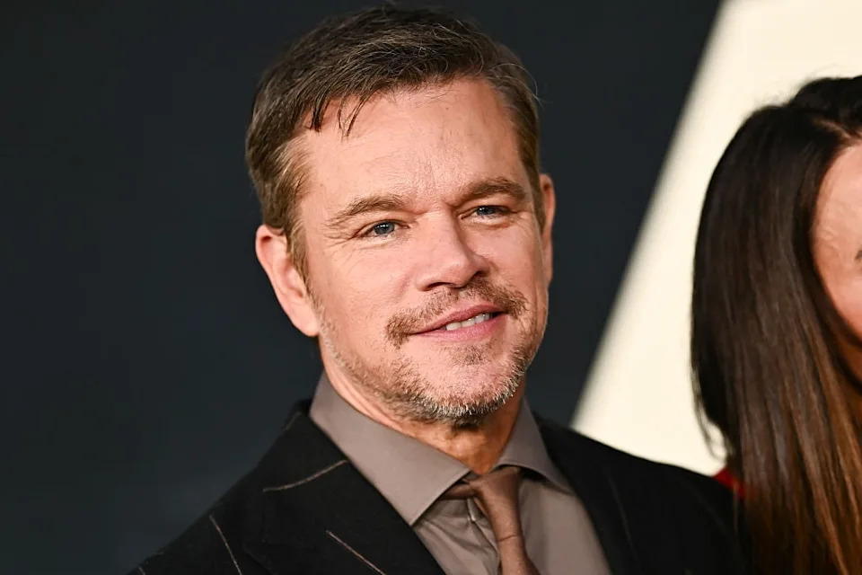 Man in a suit with a slight smile at an event