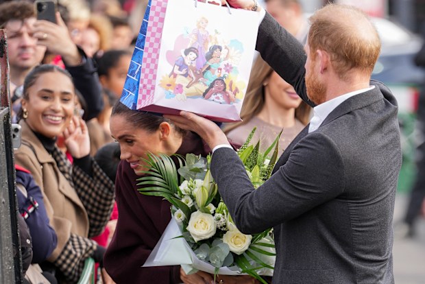 Meghan, Duchess of Sussex and Prince Harry, Duke of Sussex receive gifts from well-wishers as they arrive at the Community Recording Studio (CRS), 