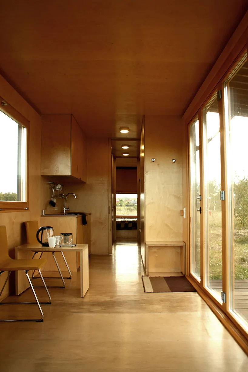 Innovative Birch Plywood Interior Transforms Shipping Container into Modern Micro-Cabin Interior lined with BB-grade birch plywood panels for warm ambiance.