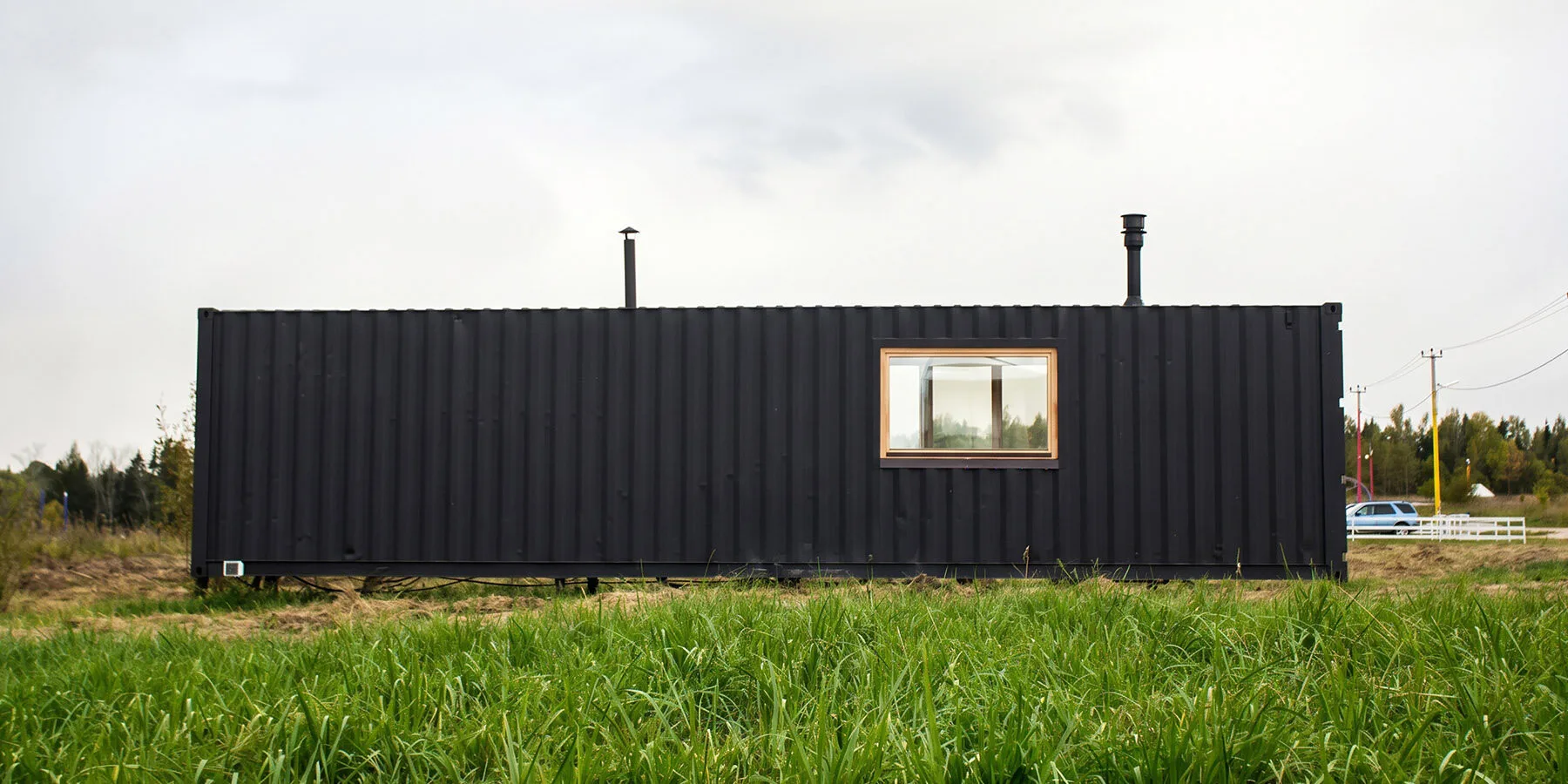 Innovative Birch Plywood Interior Transforms Shipping Container into Modern Micro-Cabin Industrial steel profile maintained on the container's exterior.