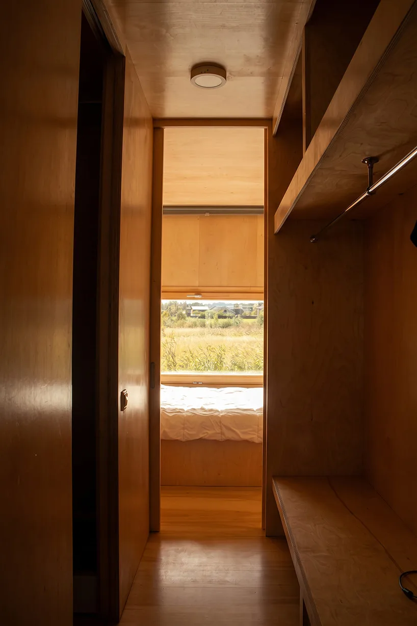 Innovative Birch Plywood Interior Transforms Shipping Container into Modern Micro-Cabin Double bedroom located at rear section of the micro-cabin.