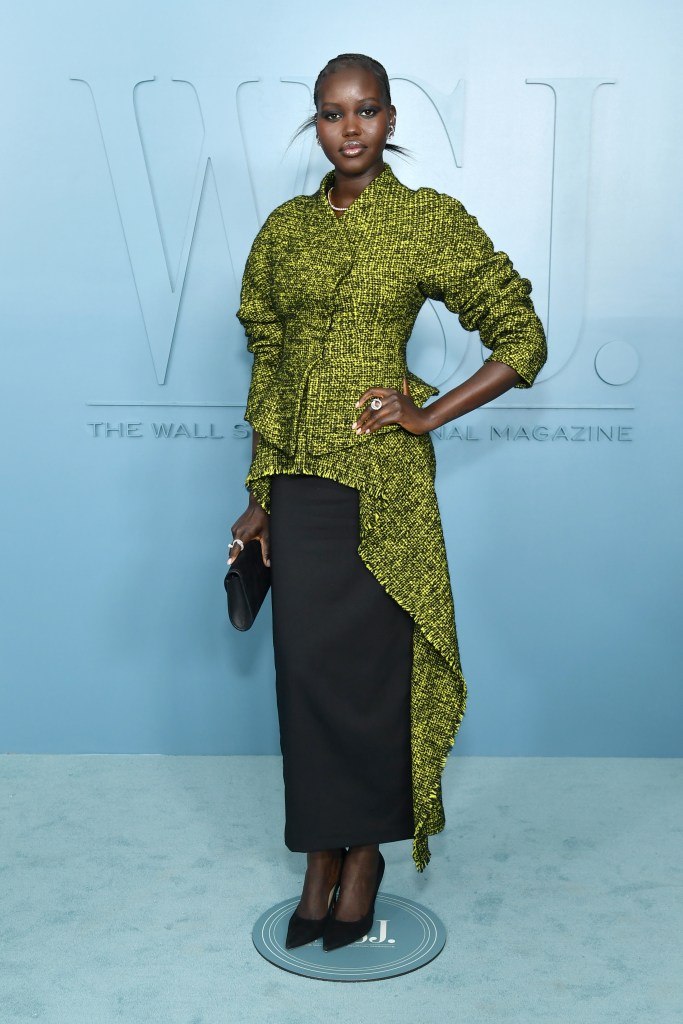 Adut Akech wears a textured yellow-green jacket with an asymmetrical hem and a long black skirt at the WSJ. Magazine Innovator Awards.