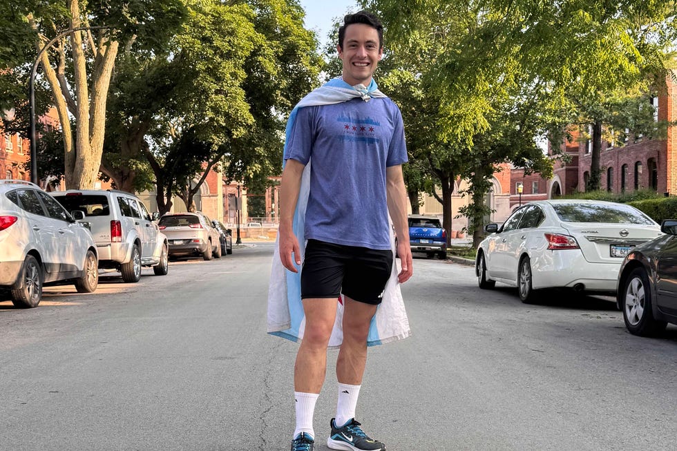 Man wearing a cape standing in the middle of a tree-lined street. Man wearing a cape standing in the middle of a tree-lined street.