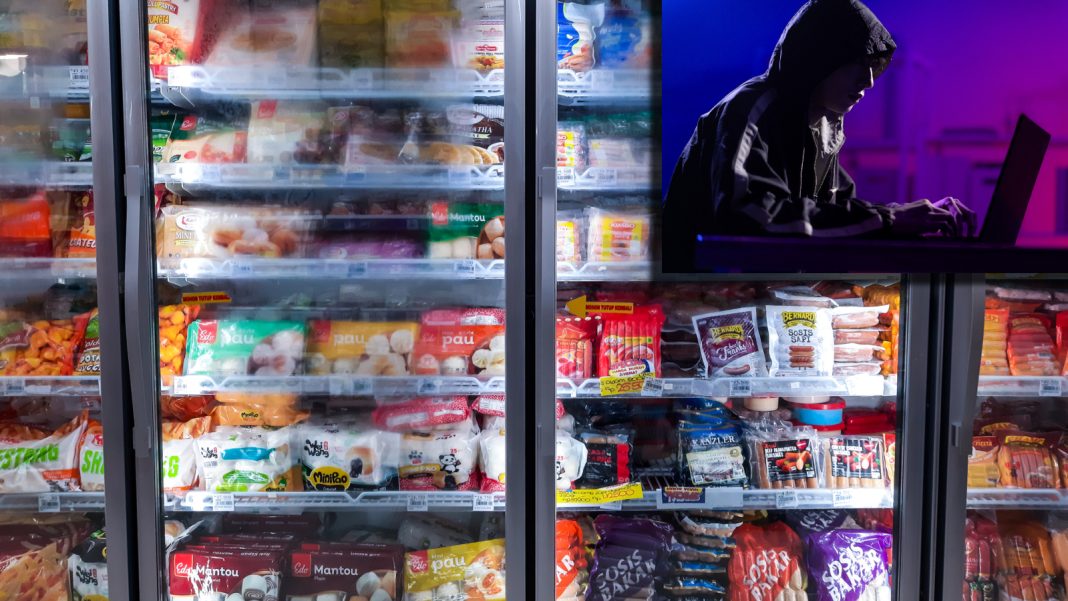 Hackers Target Grocery Stores In France With Cyber Attack On Food ominous image of a hacker next to a grocery store freezer aisle