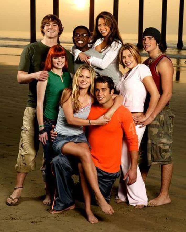 Group of seven friends smiling on a beach at sunset. Group of seven friends smiling on a beach at sunset.